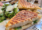 A grilled panini served with dressed greens