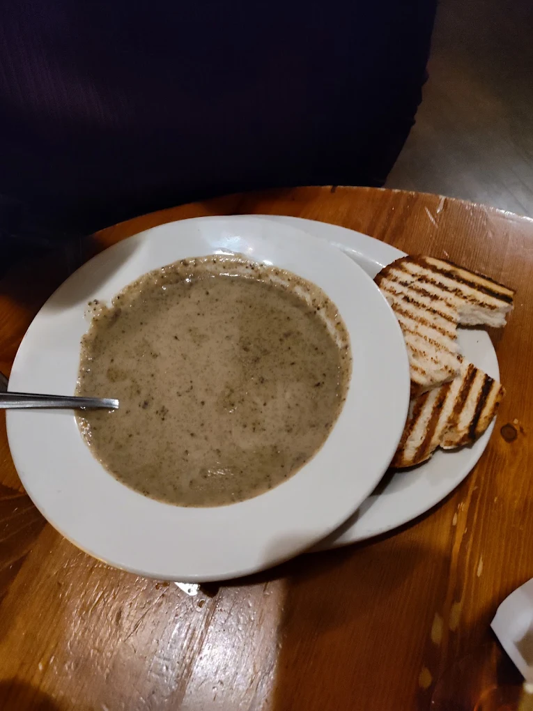 A bowl of soup served with grilled bread