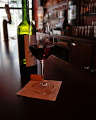 A glass of red wine resting on the bar